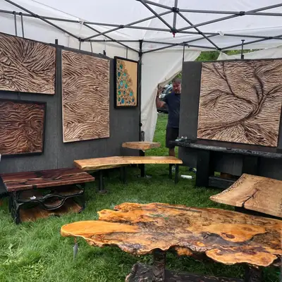 Resurfaced Colorado booth at a Colorado art festival with carved wood wall panels hung and live edge tables displayed
