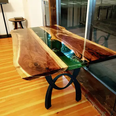 Live edge walnut river table with emerald green epoxy running through the centre, in a sunlit room